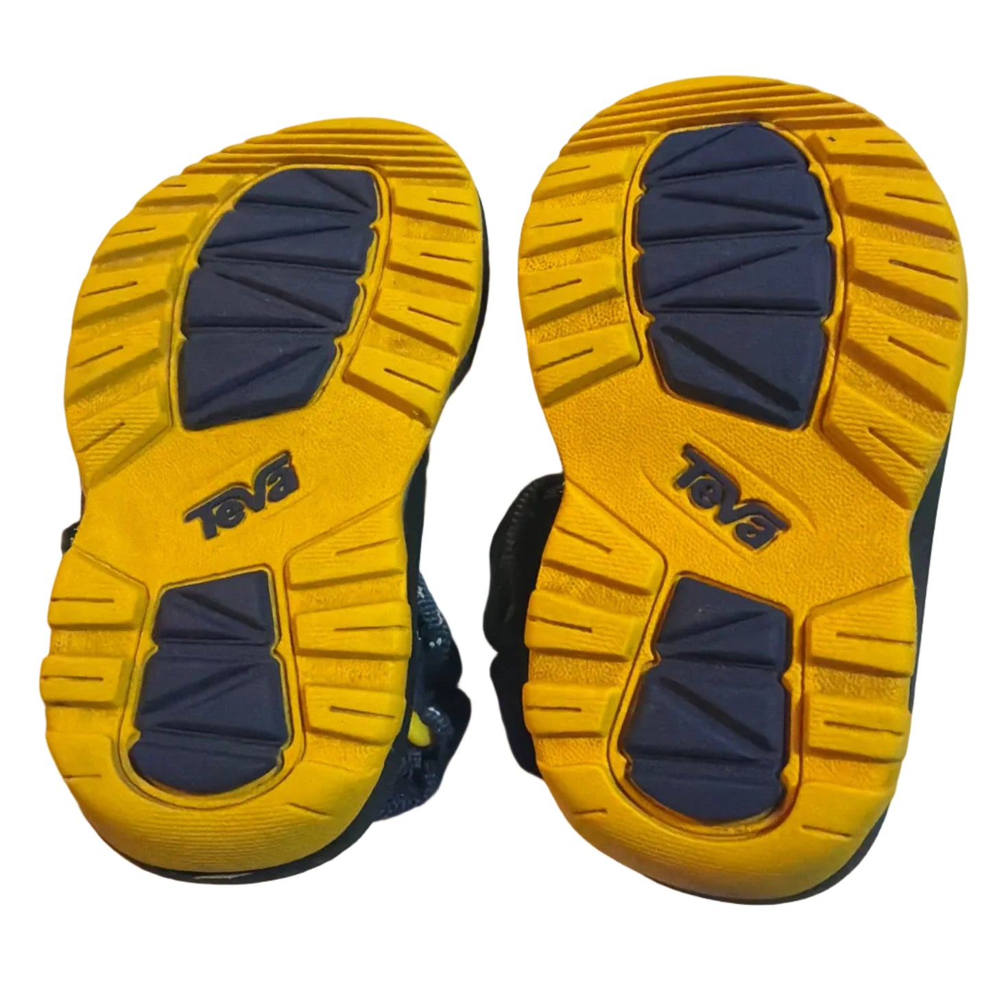 A pair of children's shoes shown from the bottom, displaying their yellow and navy blue treaded soles with the brand name 'TOG' visible.