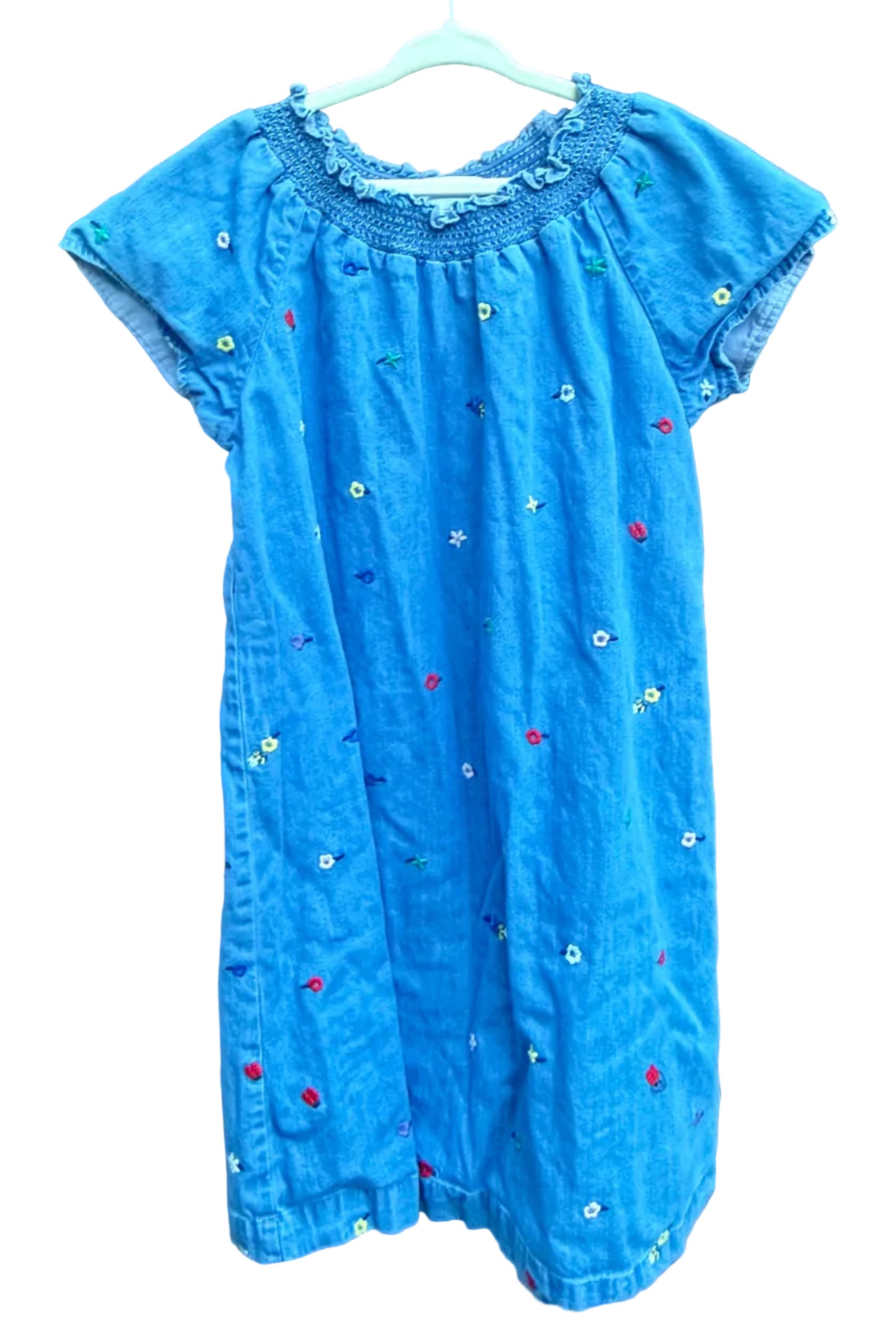 Blue baby romper with star and flower patterns on a brick surface