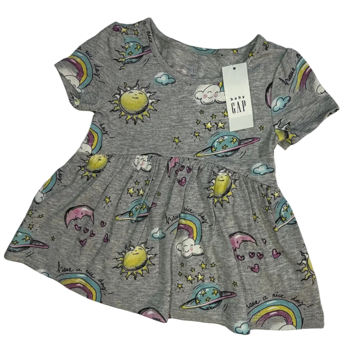 A children's short-sleeve gray dress with an all-over space-themed print featuring colorful rainbows, yellow suns, planets, and stars, shown with a hanging GAP tag on a white fabric background.