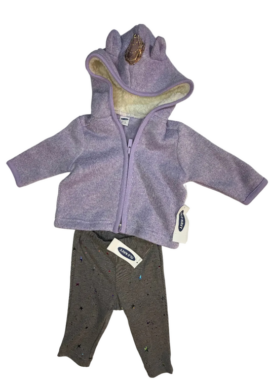 Baby clothing set including a lavender purple unicorn-themed hooded zip-up fleece jacket with a cream sherpa lining and horn, paired with dark gray leggings with small colorful star patterns. Both pieces have Baby Trend tags attached, laid flat on a white sheet.