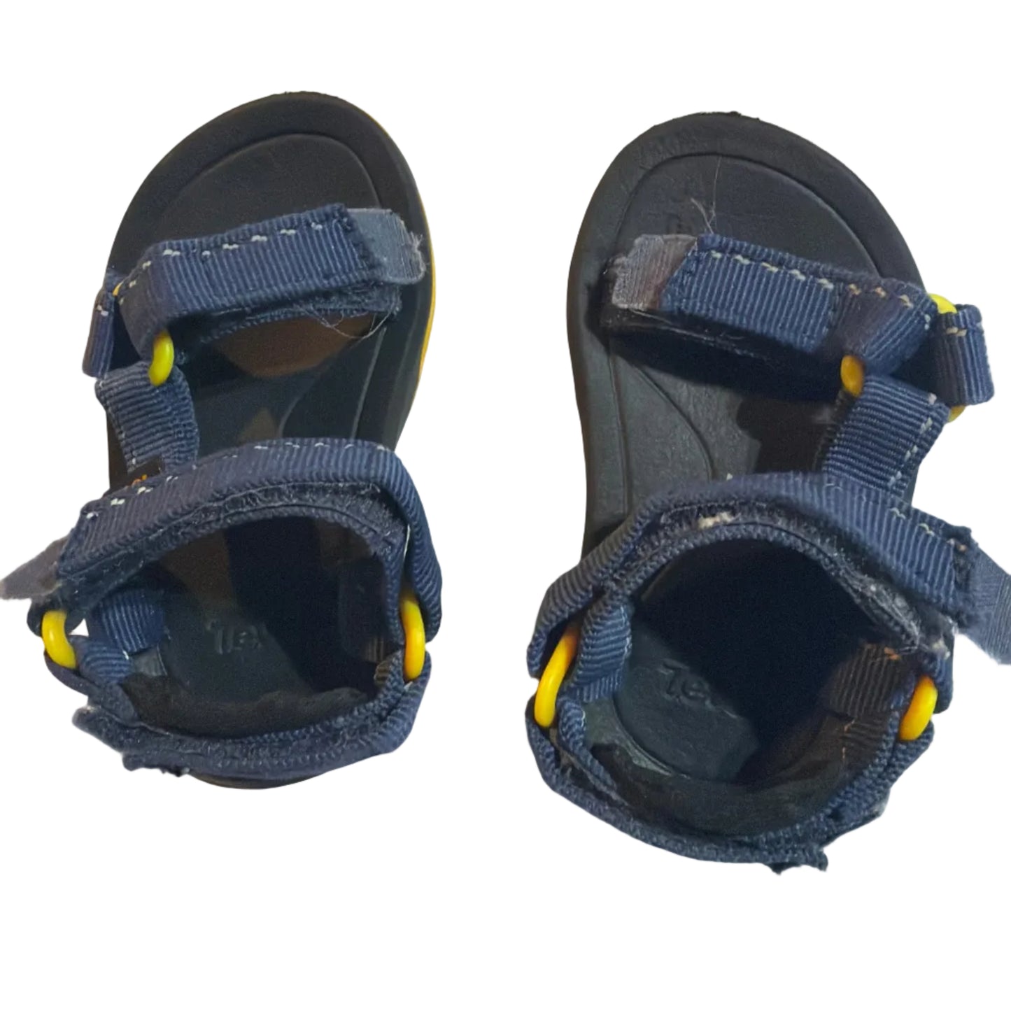 A pair of children's navy blue sandals with yellow accents, photographed from above on a light-colored surface.