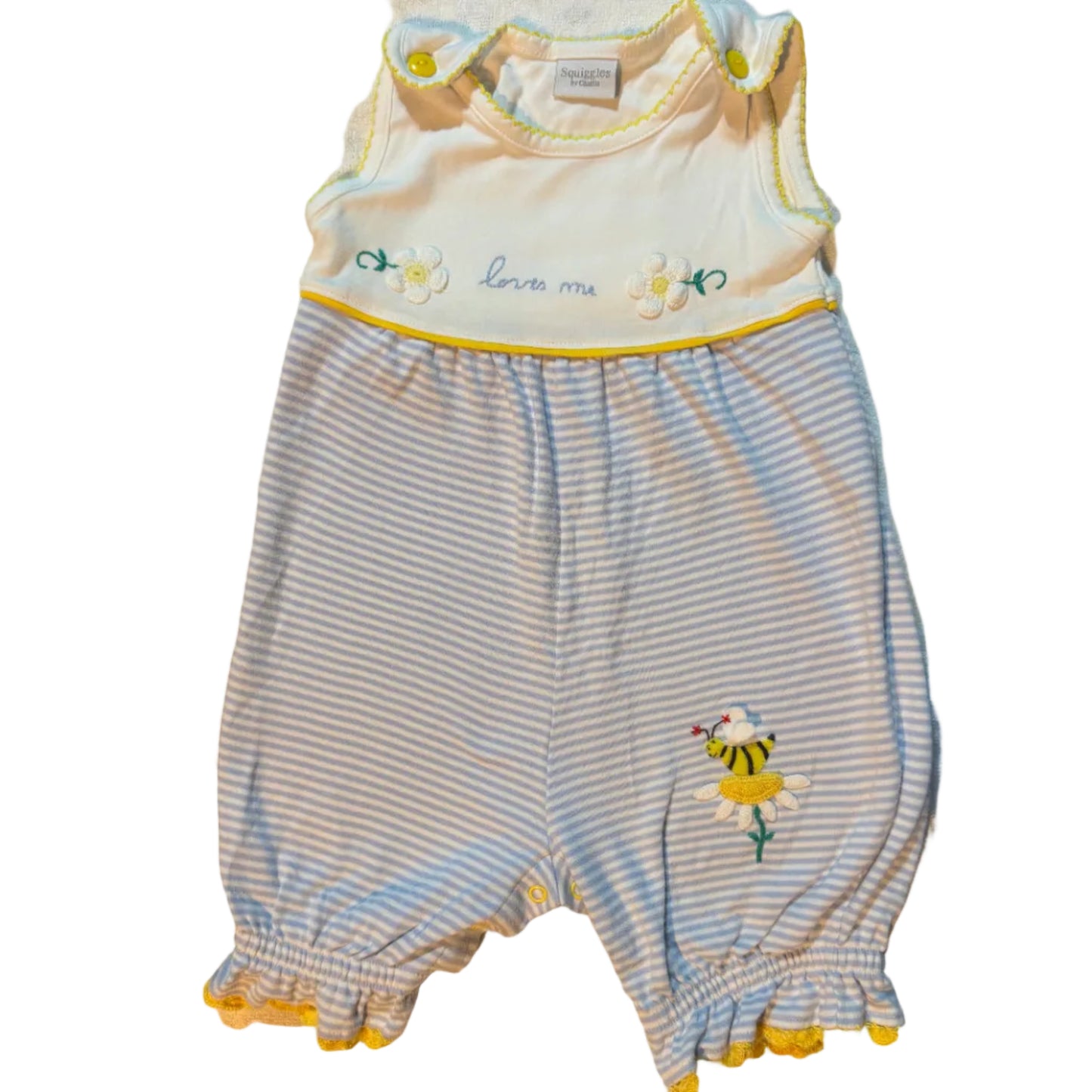 A baby romper and matching diaper cover set laid flat on a white towel. The romper has light blue and white stripes, a yellow ruffle trim, and a small embroidered tiger motif.
