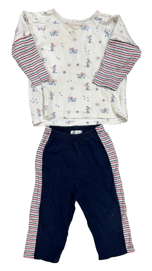 A toddler's two-piece clothing set laid flat on a light wood floor, featuring a cream long-sleeve top with a bunny print and red/white striped sleeves, paired with navy blue pants with matching red and white striped side panels.