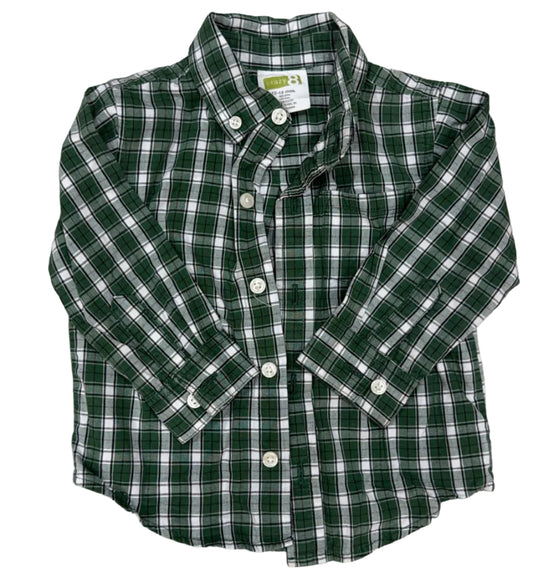 A green and white plaid long-sleeve button-down shirt laid flat on a light wood floor.