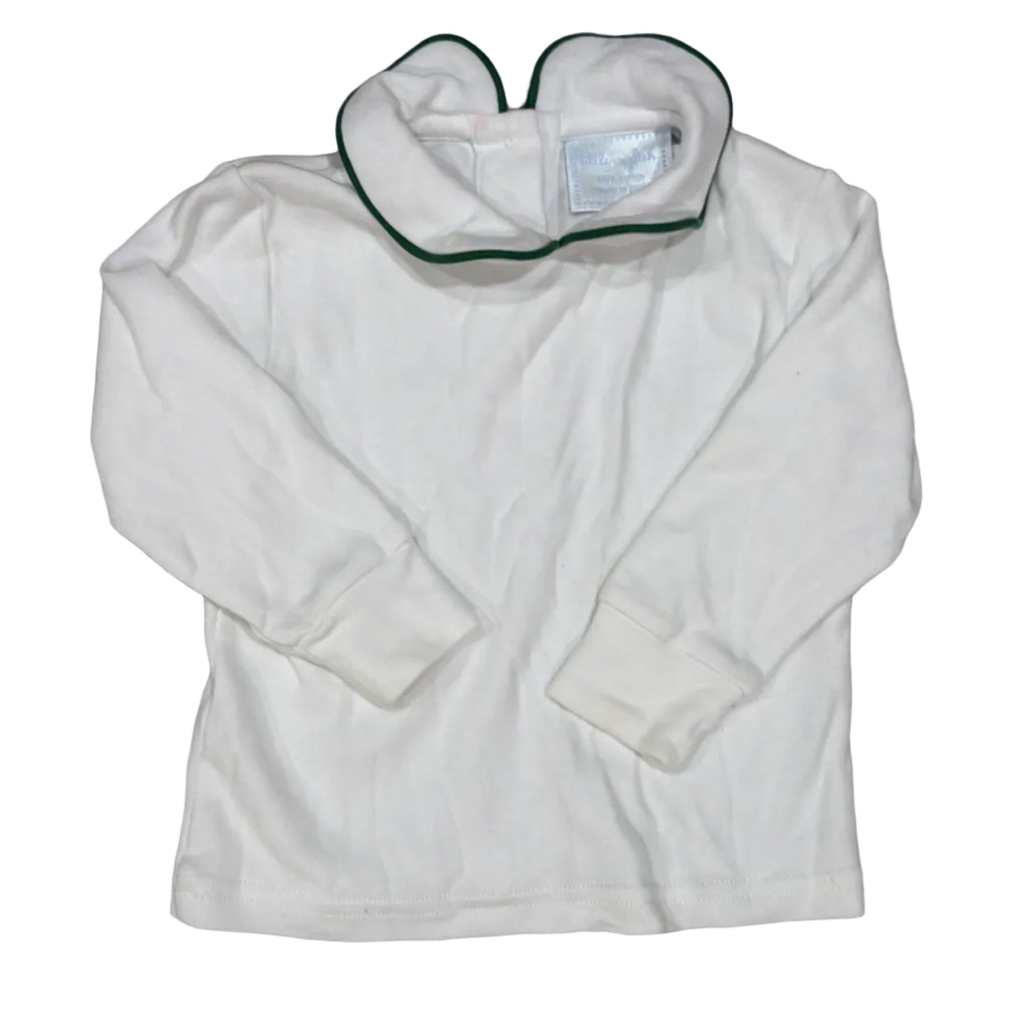 A white long-sleeve baby top with a green-trimmed mock neck collar, laid flat on a light brown wood grain surface.
