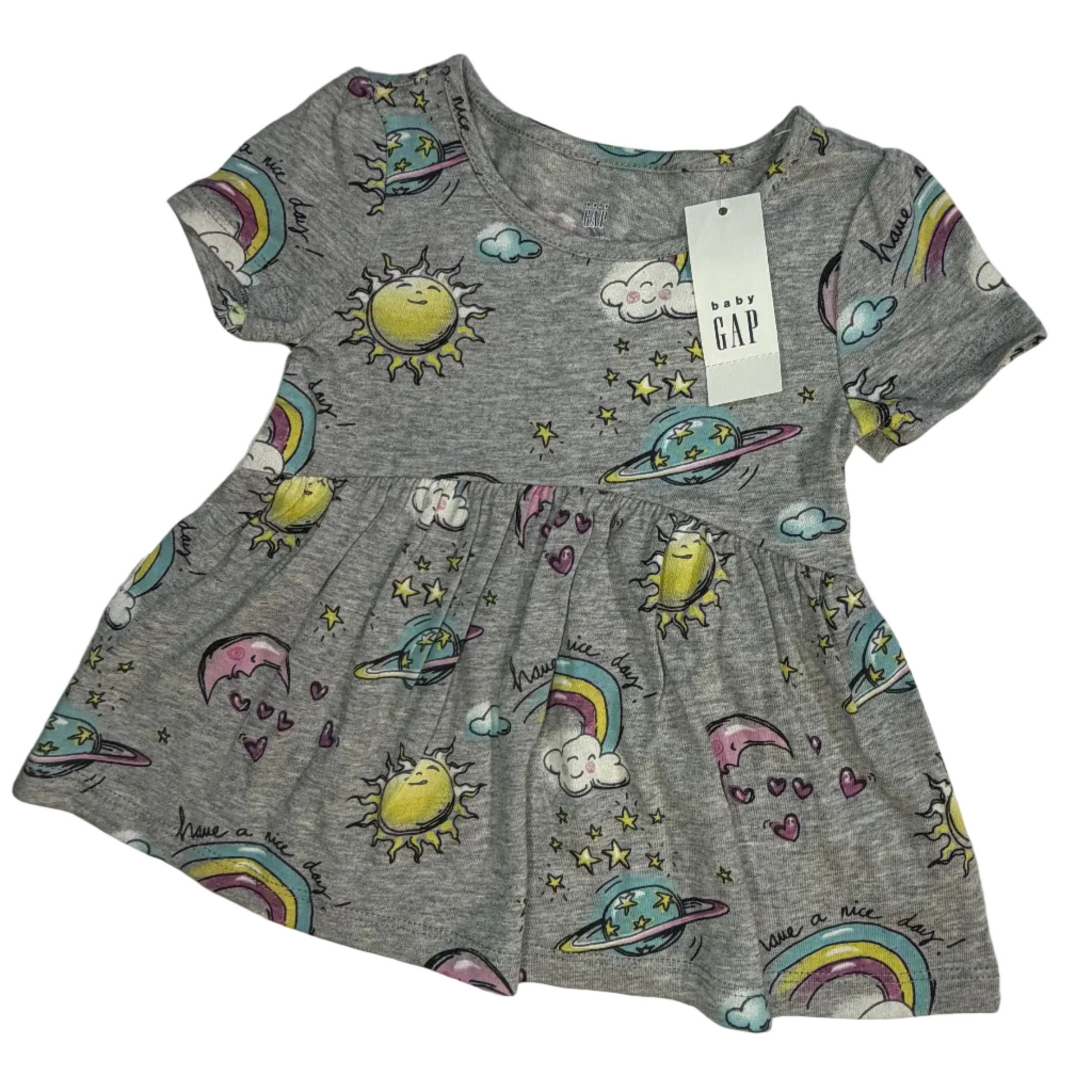 A children's short-sleeve gray dress with an all-over space-themed print featuring colorful rainbows, yellow suns, planets, and stars, shown with a hanging GAP tag on a white fabric background.