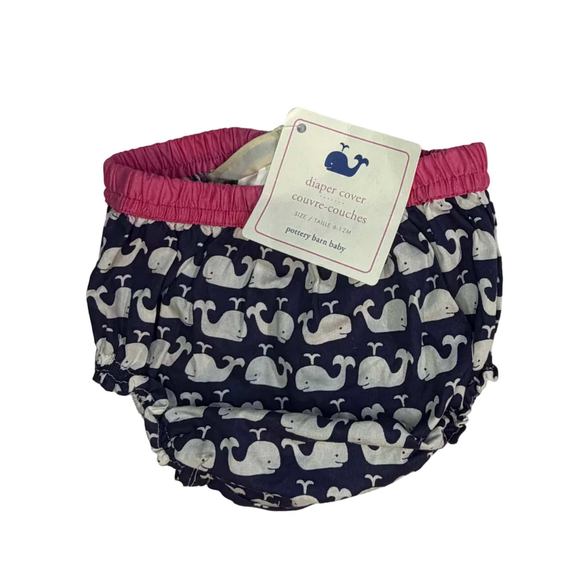 Baby swim diaper cover by Whiskers, featuring a navy blue and white whale pattern with a bright pink elastic waistband and a white paper hangtag.